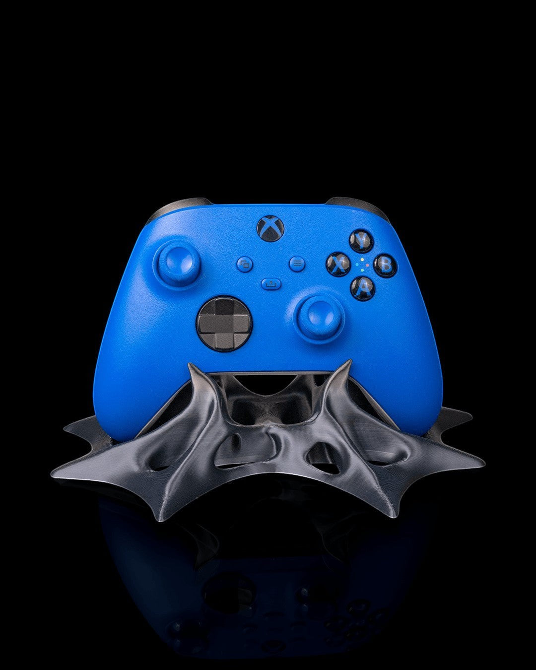 MJR Crafted blue Xbox controller on a dark grey sculptural 3D printed PLA stand with a bat-wing design.