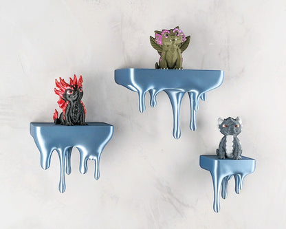 MJR Crafted blue 3D printed melting shelf with dripping effect, holding dragon figurines. Unique wall mount.