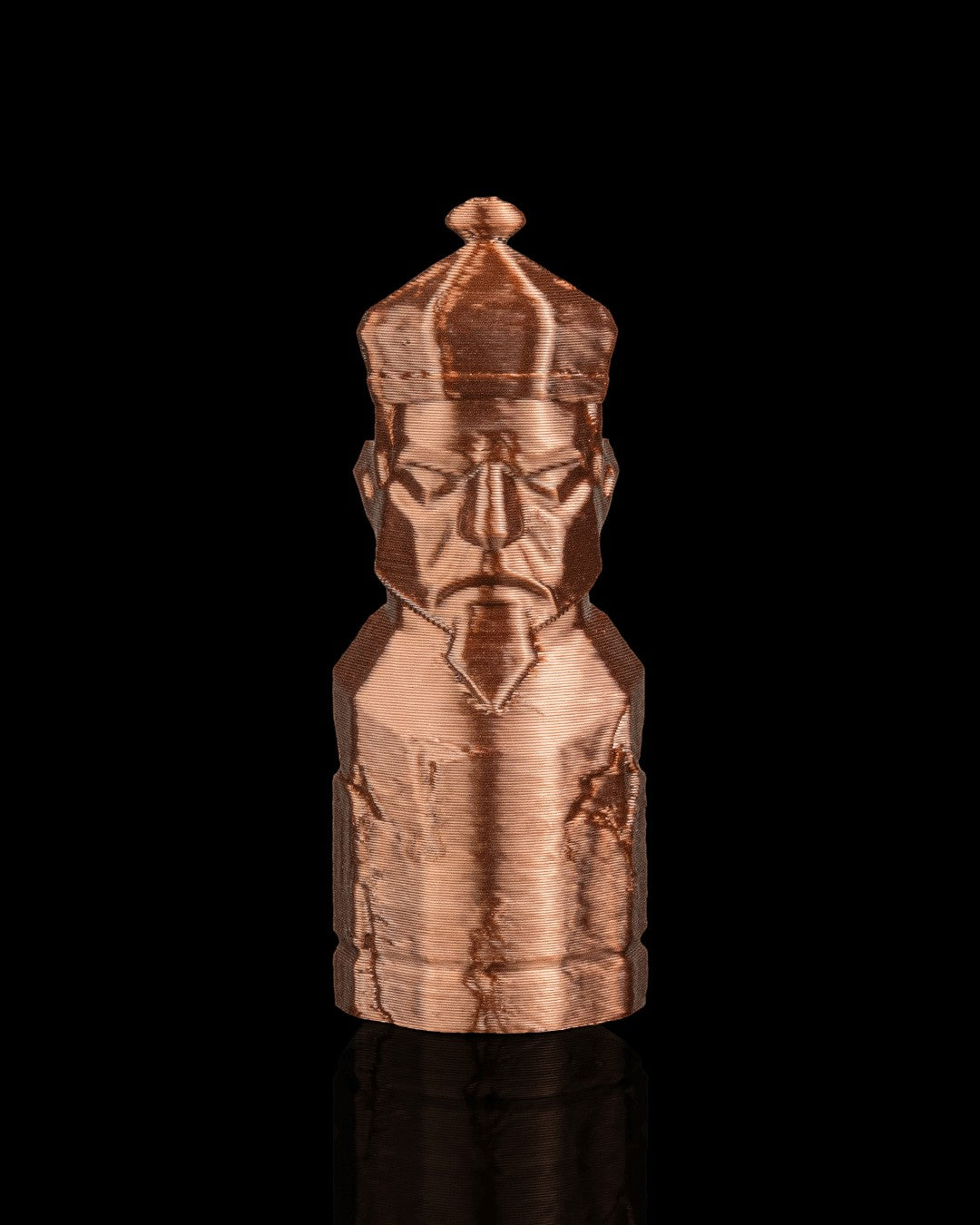 MJR Crafted copper-colored 3D printed chess bishop piece with a crown and detailed face, on a black background.