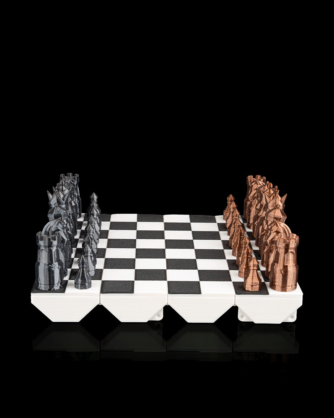 MJR Crafted fold-up chess set with black and bronze 3D printed pieces on a white and black board. Designed for travel.