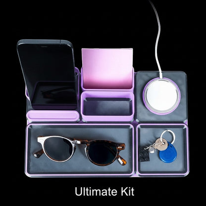 MJR Crafted modular desk organizer system in purple and grey, holding a phone, sunglasses, keys, and a wireless charger.
