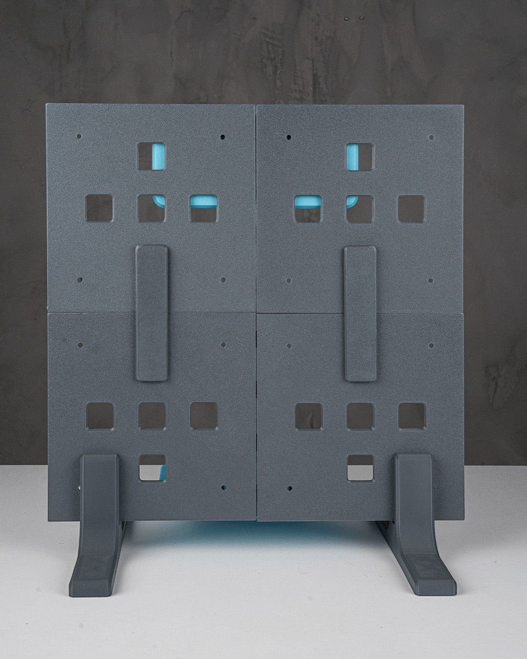 MJR Crafted modular organizer system in grey with blue accents, featuring square cutouts and supporting feet.