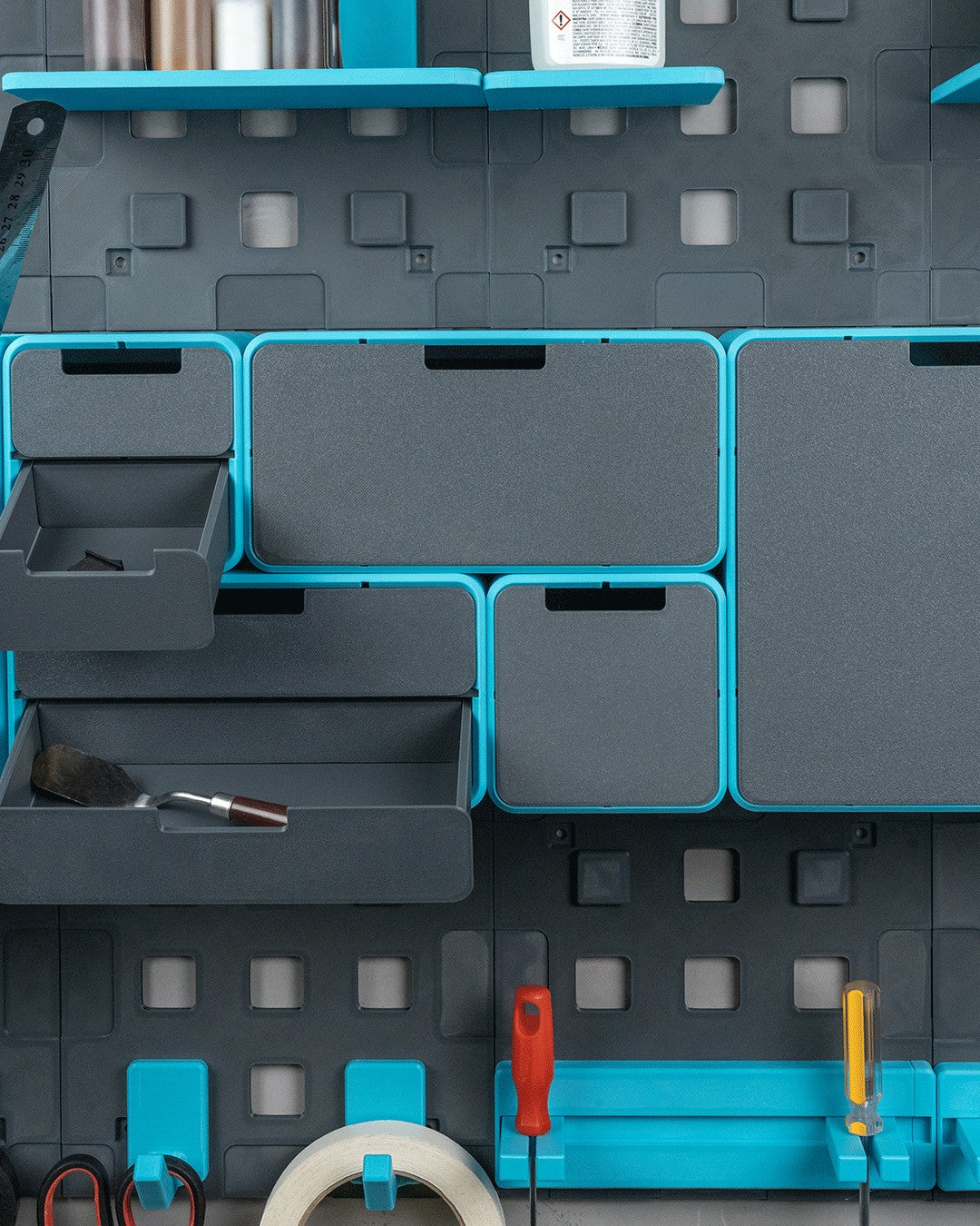 MJR Crafted modular organizer system in grey and teal, featuring drawers, shelves, and tool holders for a workspace.
