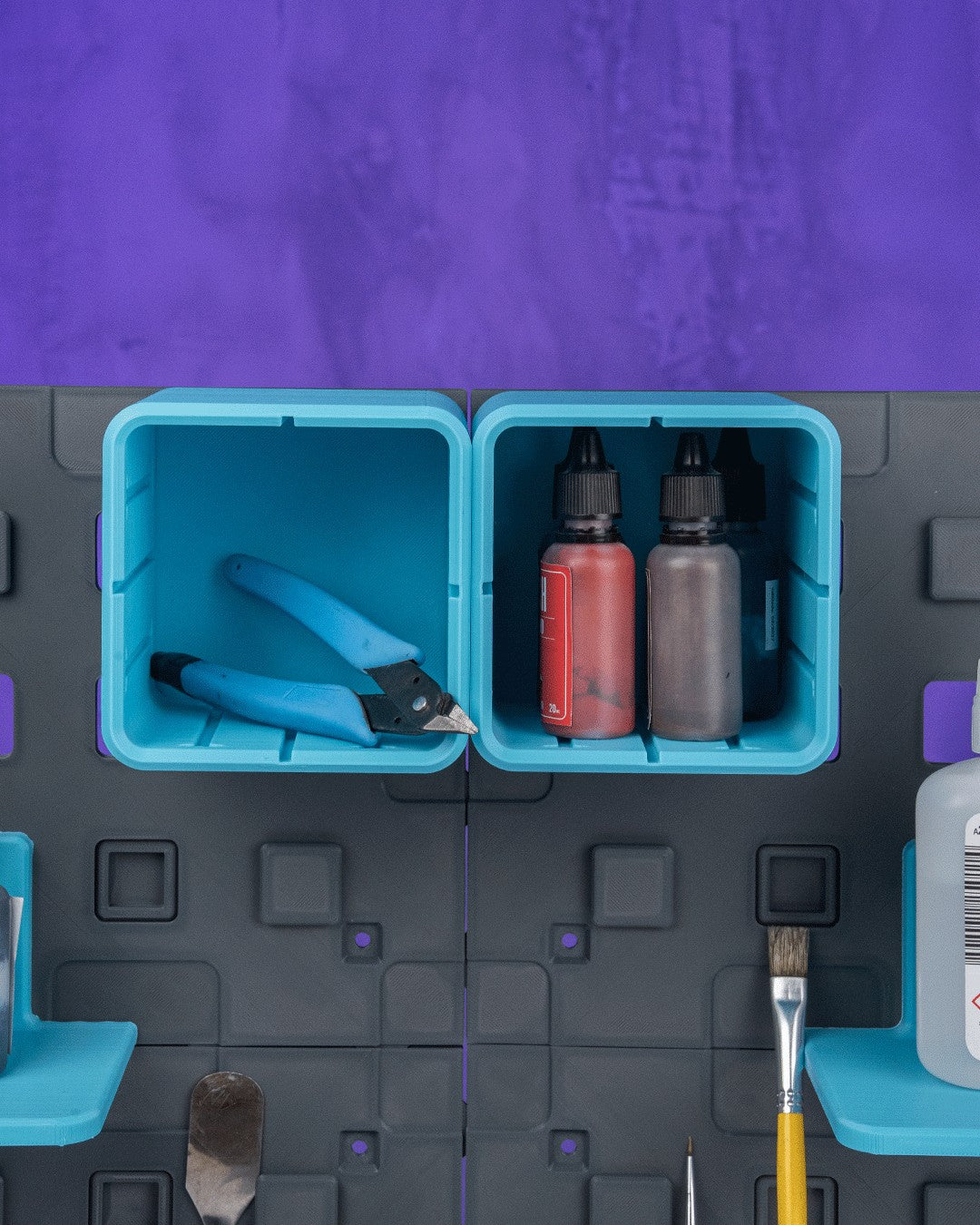 MJR Crafted modular organizer system with teal bins holding tools and bottles. Grey panels with purple accents.