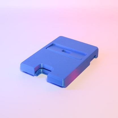 MJR Crafted blue 3D-printed foldable Nintendo Switch stand with adjustable angle and cable slot.
