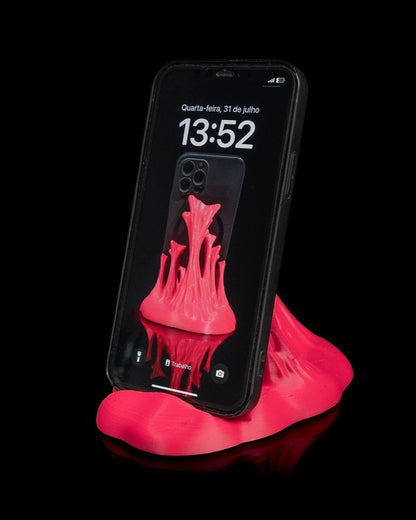MJR Crafted pink 3D printed phone stand with a sculptural wave design, holding a smartphone.