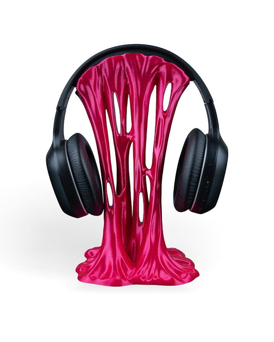 MJR Crafted pink metallic headphone stand with a dripping, melted effect, holding black over-ear headphones.