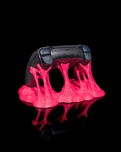 MJR Crafted pink slime-effect controller stand holding a black PS5 controller. Minimalist gaming accessory.