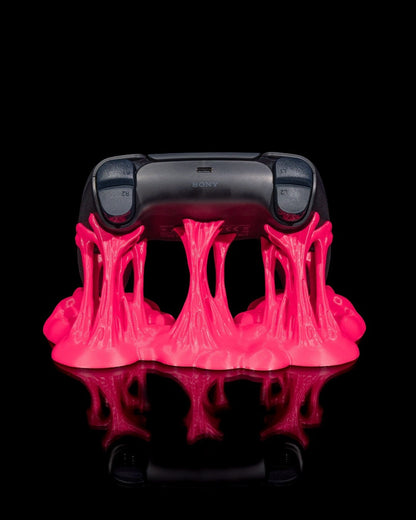 MJR Crafted pink slime-effect controller stand holding a black PS5 controller. Unique gaming accessory.