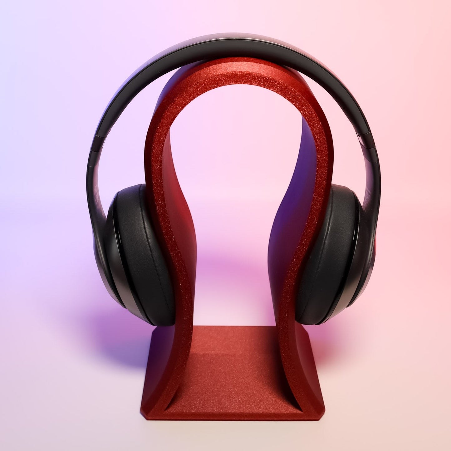 MJR Crafted red glitter sculptural headphone stand holding black over-ear headphones.