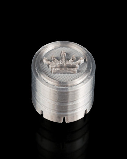 MJR Crafted silver 3D printed cylindrical herb grinder with crown emblem on top and serrated edge.
