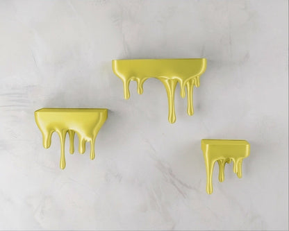 MJR Crafted yellow 3D printed melting shelf with a unique dripping design, mounted on a marble-effect wall.
