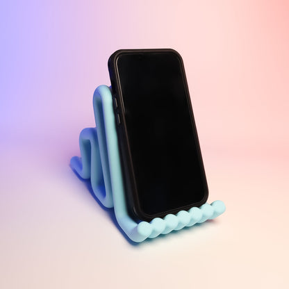 MJR Crafted light blue wavy phone stand holding a black smartphone, perfect for desks.